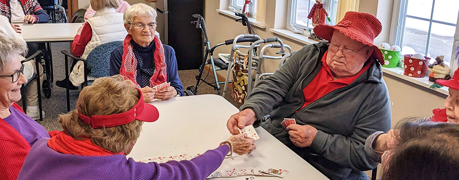 Red Hatters group plays cards with Morningside seniors