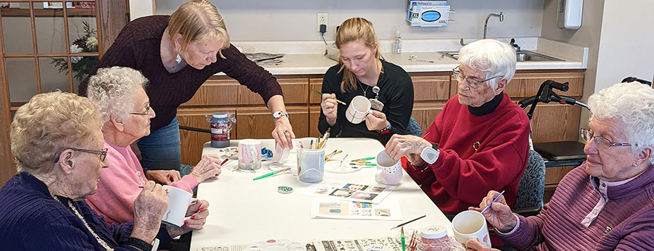 Local teachers help Morningside seniors glaze ceramic mugs.
